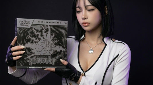 Pokemon Mega Evolution Pitch Black Elite Trainer Box held in editorial product photography, presented by the Evol Vault content host on a dark studio backdrop