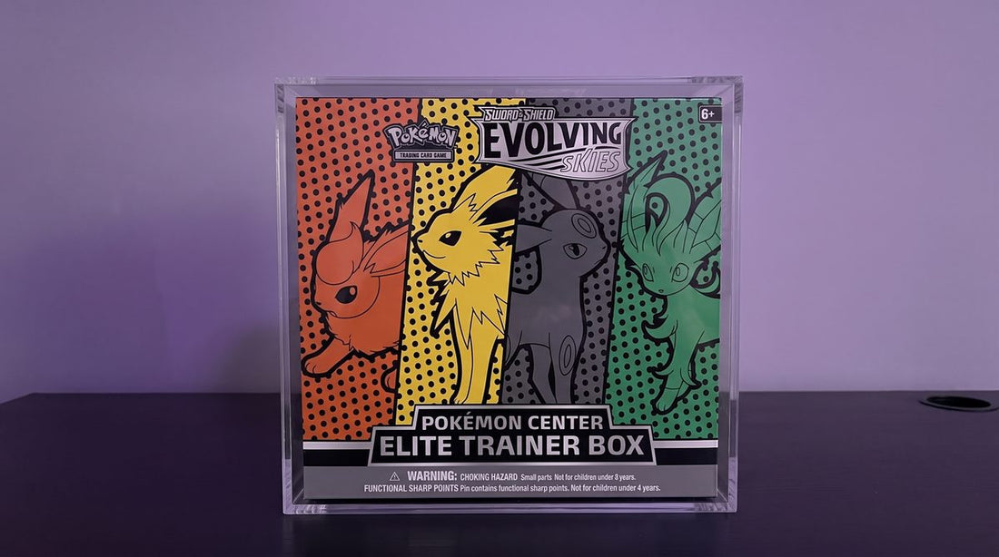 A sealed Evolving Skies Pokemon Center Elite Trainer Box in a clear acrylic case on a black desk